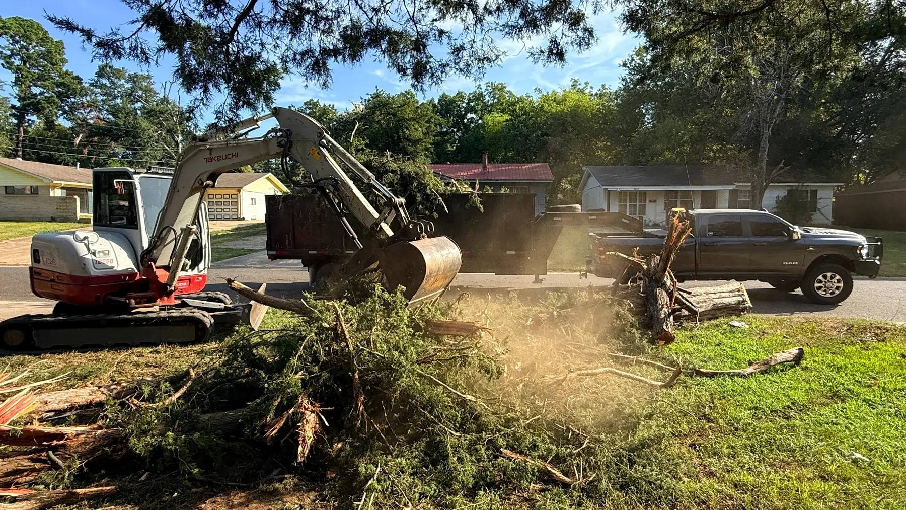 Fusion Land equipment clearing storm debris on a wooded property